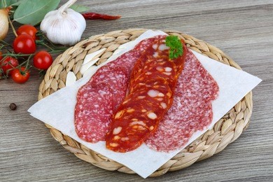 salami sausage with parsley on the wood background