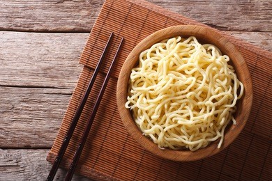 asian ramen noodles in wooden bowl on the table. horizontal view from above
