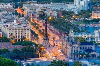 aerial view over square portal de la pau, and port vell marina and columbus monument at evening in barcelona, catalonia, spain