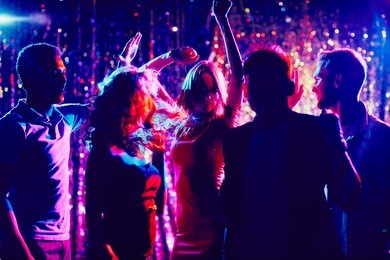 group of guys and girls dancing in the night club