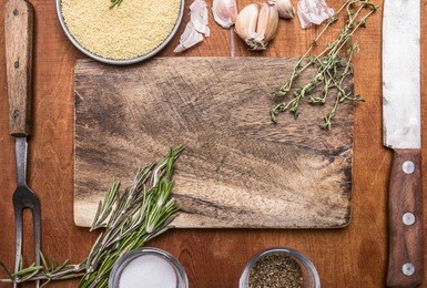 couscous herb knife meat fork garlic and salt seasoning cutting board. ingredients on wooden rustic background close up top view