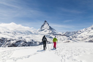 men walking on ski in the background of matterhorn, zermatt, switzerland.