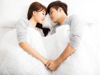 happy young lovely couple lying in a bed