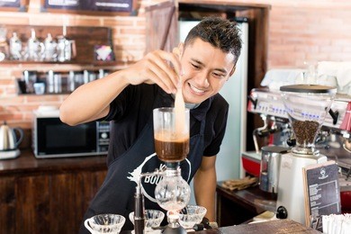 barista preparing drip coffee in asian coffee shop using professional machine parts 