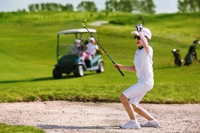 boy playing golf and enjoing on the successful hit