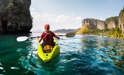 lady paddling the kayak in the calm tropical bay