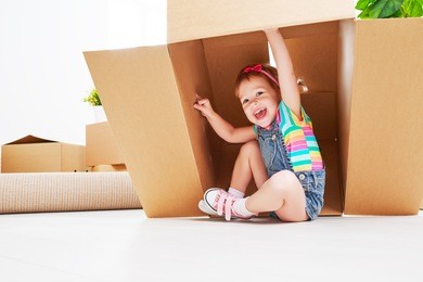 moving to a new apartment. happy child in a cardboard box