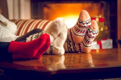 closeup photo of family warming feet at fireplace