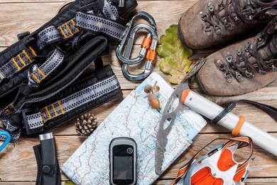 equipment for mountaineering and hiking on wooden background.