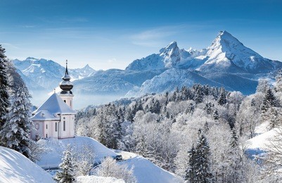 panoramic view of beautiful winter wonderland mountain scenery in the alps with pilgrimage church of maria gern and famous watzmann summit in the background, berchtesgadener land, bavaria, germany