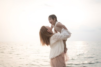 asian mother and son playing on the beach,vintage filter