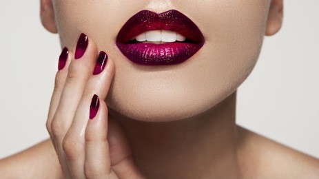 closeup shot of a girl applying colorful lipstick