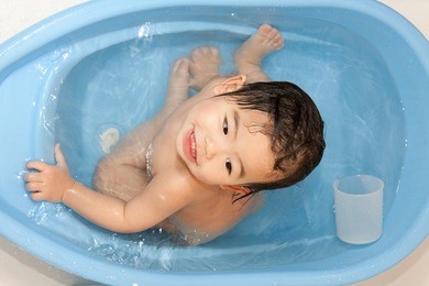 baby girl in bath tub smiling