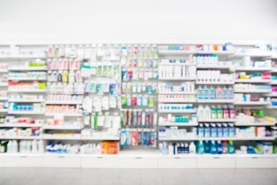 defocused image of medicines arranged in shelves at pharmacy