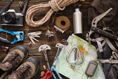 equipment necessary for mountaineering and hiking on wooden background