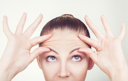 portrait of a young woman with wrinkles on his forehead on white
