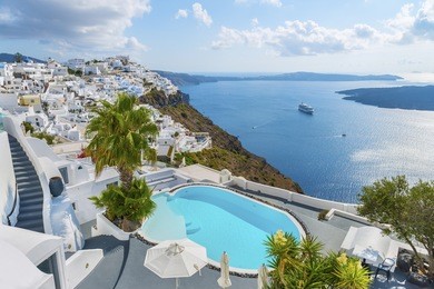 white architecture at santorini (thira) island. swimming pool in romantic luxury hotel at fira town. beautiful panoramic view on the mediterranean sea, caldera and volcano.cyclades.greece.europe.  