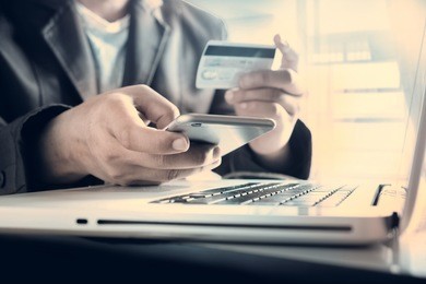 online payment,man's hands holding a credit card and using smart phone for online shopping
