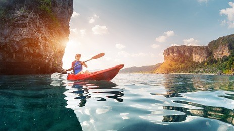 lady paddling the kayak in the calm tropical bay