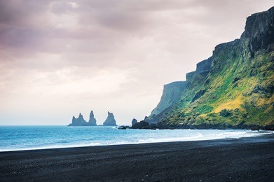 famous reynisdrangar rock formations and the mount reynisfjall. black beach in vik, southern iceland
