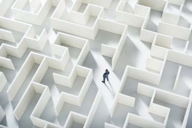 business challenge. a businessman navigating through a maze. top view