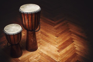 two old vintage style wooden djembes, percussion instruments from balkan and africa. 
