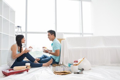 asian couple talking and eating instant noodle after moving to new house