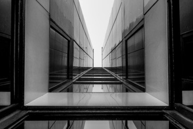 urban geometry, looking up to glass building. modern architecture, glass and steel. abstract architectural design. inspirational, artistic image. industrial design. .modern building. black and white.