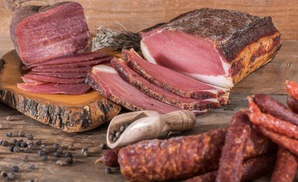 smoked meats and sausages on wooden background