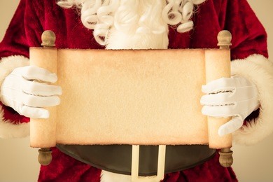 santa claus holding scroll paper blank in hands. christmas holiday concept