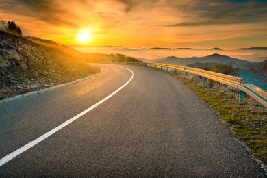 driving on an empty asphalt road towards the rising sun at autumn season in mountain area. mountain golija, serbia.