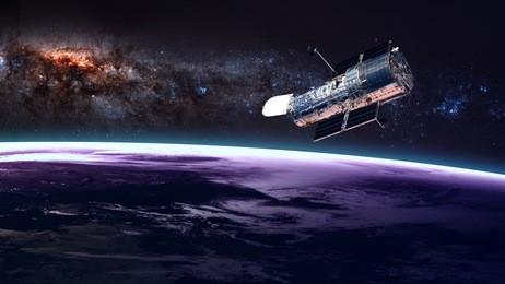 the hubble space telescope in orbit above the earth. elements of this image furnished by nasa.