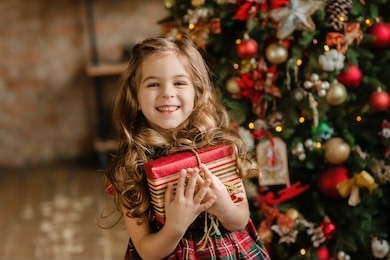 happy little smiling girl with christmas gift box.