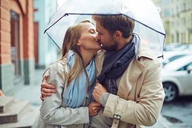 loving young couple in love under umbrella in the rain