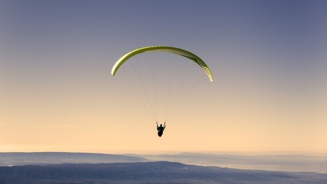 yellow paragliding on pastel  sky