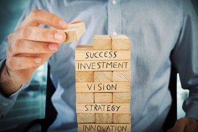 businessman make a building with wood blocks