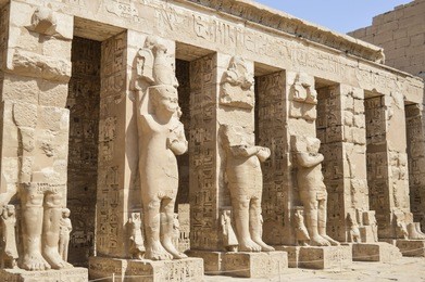 statues of a pharaoh at the temple of medinat habu courtyard in luxor
