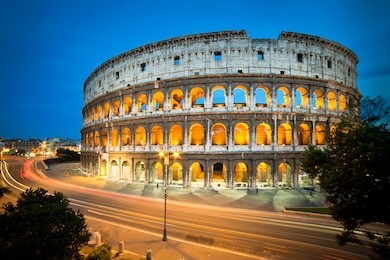 colosseum at night with colorful blurred traffic lights. rome - italy.