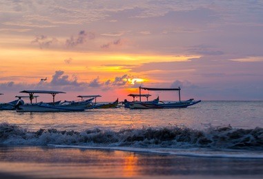 sunrise over fishing boats in kuta bali