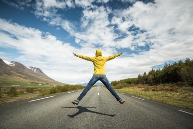 woman jumping on a beautiful road 