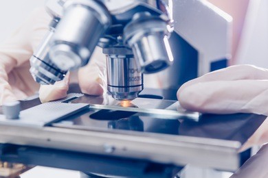 scientist hands with microscope close-up shot in the laboratory