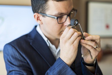 jeweler examining diamond thoroughly through loupe