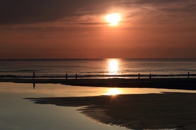 my khe beach in danang city vietnam. the sunrise was reflected in the pond before the beach. my khe beach among the 6 most luxurious in the world. people doing exercise in the morning.