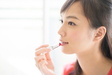 young woman making up with a lipstick