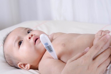 digital thermometer,mother check the temperature of asian baby