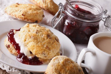 english pastries: scones with jam and tea with milk close-up on the table. horizontal