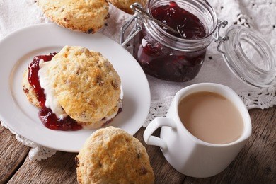 homemade scones with jam and tea with milk close-up on the table. horizontal
