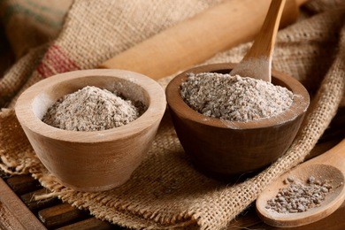 buckwheat flour in the wooden bowl on the table