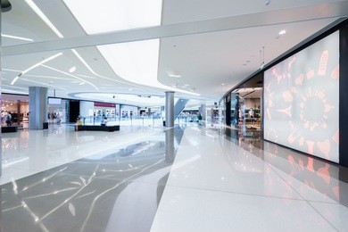 empty hallway with a huge billboard and abstract ceiling in modern shopping mall