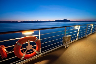 view from the upper deck of a cruise ship sailing in alaska at dusk.